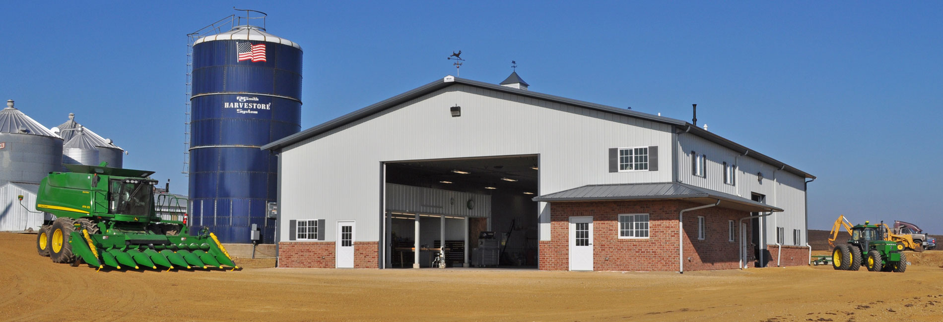 post frame agricultural building showing tractor equipment and a silo